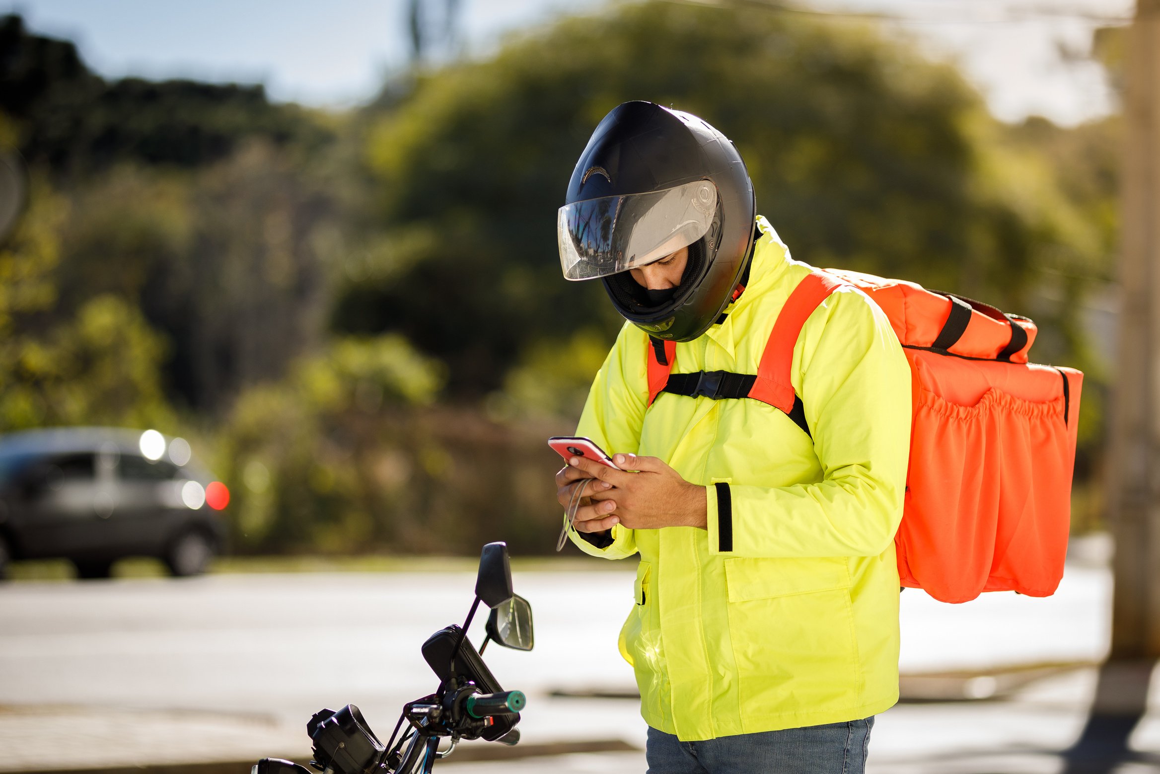 Delivery biker checking phone - motoboy